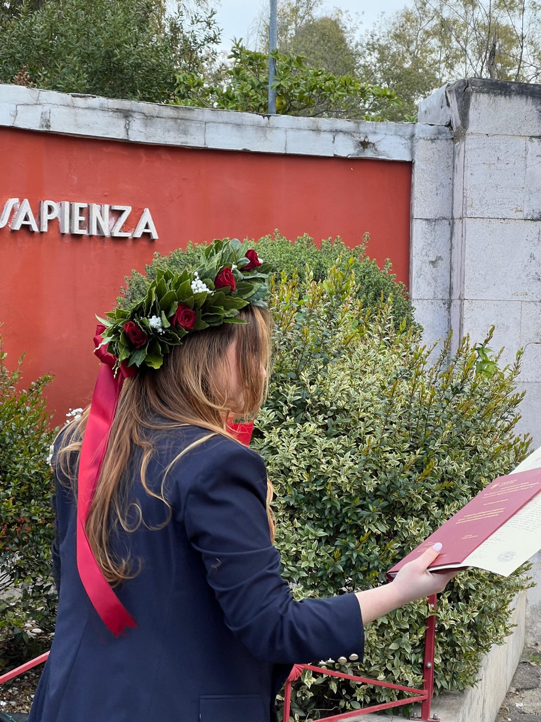Corona d'alloro per laurea con rose rosse e tesi universitaria
