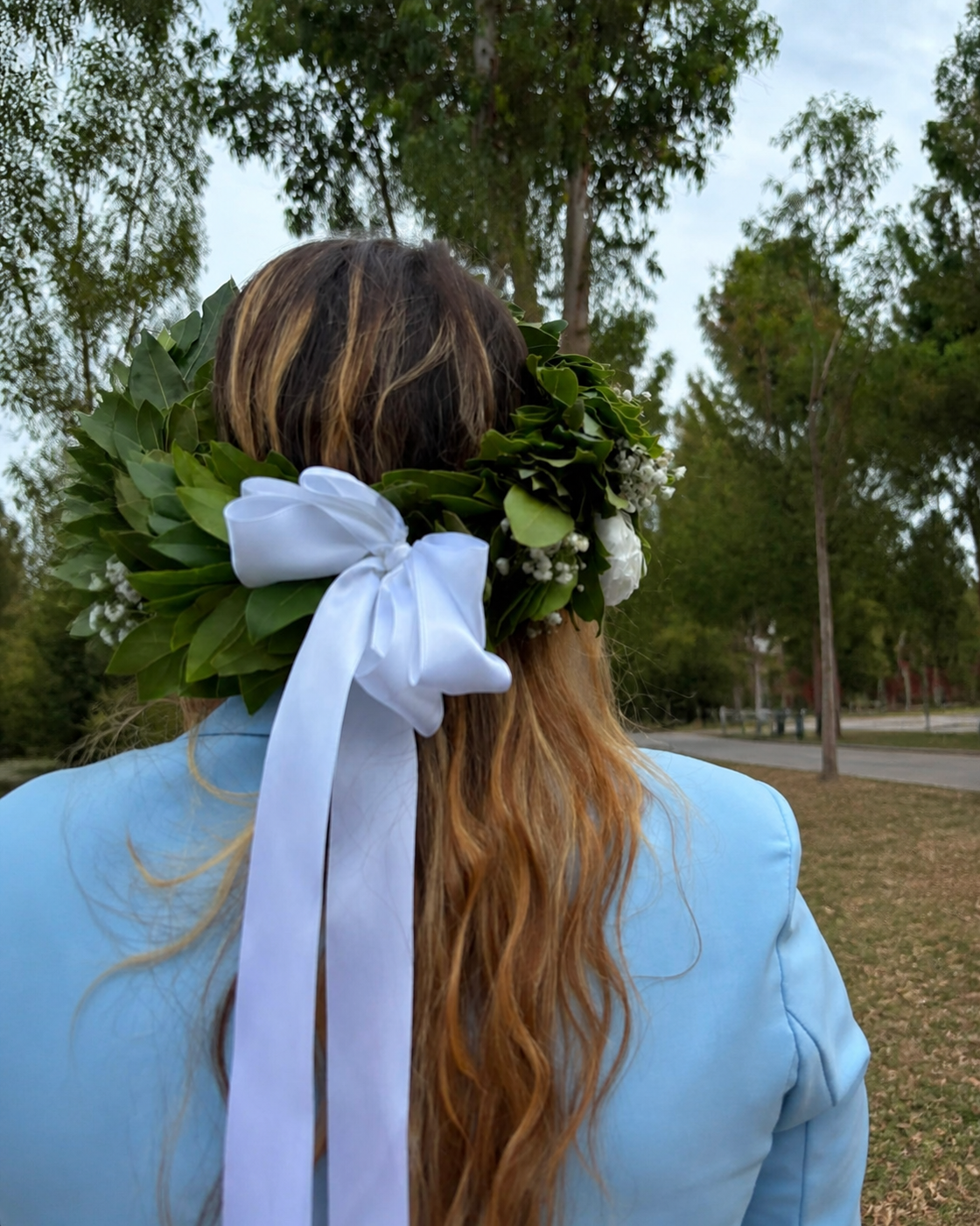 Laureata di spalle con corona d’alloro, fiori bianchi e fiocco bianco